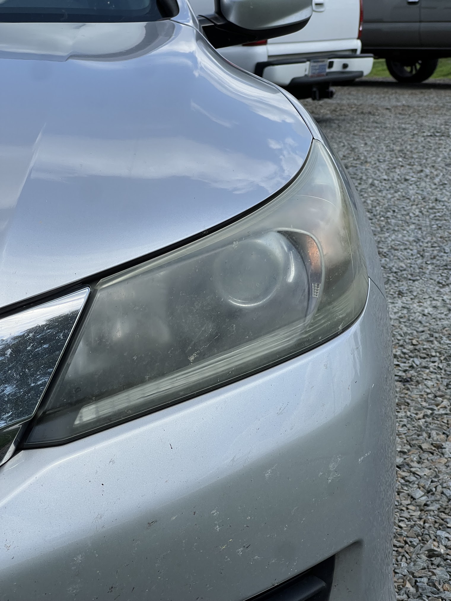 Before restoration: cloudy exterior lens on a silver Honda